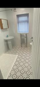 a bathroom with a sink and a toilet and a window at Border cottage in Earby