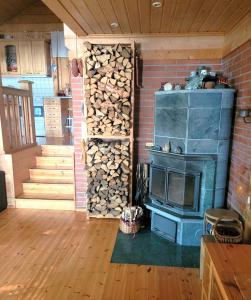 a room with a stove and a pile of fire wood at Villa Okra in Rastinniemi