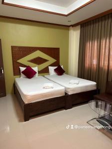 1 dormitorio con 2 camas y almohadas rojas en Buddha Raksa, en Thong Nai Pan Yai