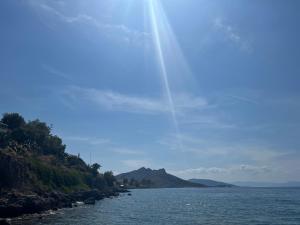 a view of a body of water with the sun shining at Perdika's Nest, family friendly house by the sea in Perdika