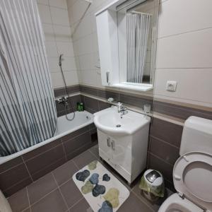 ein Bad mit einem WC, einem Waschbecken und einer Dusche in der Unterkunft On Top 21 in Bijeljina