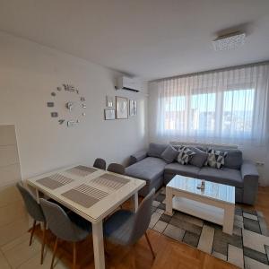 ein Wohnzimmer mit einem Sofa und einem Tisch in der Unterkunft On Top 21 in Bijeljina