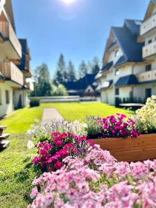 a bunch of flowers in front of some buildings at Nosal Ski & Wine Apartments in Zakopane