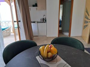 a bowl of fruit sitting on top of a table at jardin kapetanova kuća in Veli Iž