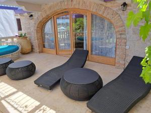 a patio with two benches and a table andools at jardin kapetanova kuća in Veli Iž