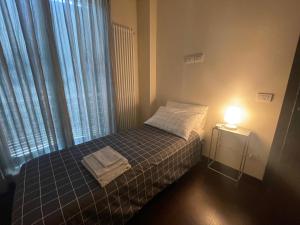 a small bedroom with a bed and a lamp at Villa I tre Cipressi in Lido di Camaiore