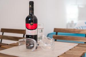 una botella de vino sentada en una mesa con copas en Casa GianAngel Ostuni en Ostuni