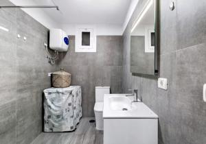 La salle de bains est pourvue d'un lavabo blanc et de toilettes. dans l'établissement Roque Mar Apartamento Atardecer, à Santa Cruz de Tenerife