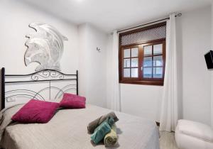 - une chambre avec un lit doté d'oreillers violets et d'une fenêtre dans l'établissement Roque Mar Apartamento Atardecer, à Santa Cruz de Tenerife