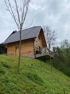 ein Blockhaus auf einem Hügel mit einer Terrasse in der Unterkunft Apartman Lenka in Mokra Gora