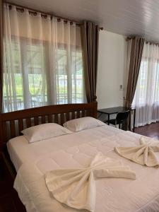 ein großes weißes Bett mit einem Handtuch drauf in der Unterkunft Buddha Raksa in Thong Nai Pan Yai