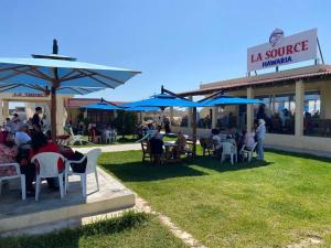 a group of people sitting under umbrellas outside a restaurant at Villa Baya in El Haouaria