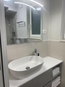 Un baño con un lavabo blanco y un espejo. en Apartman Martinac, en Split