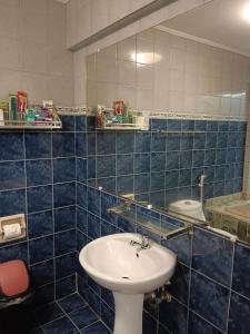 Baño de azulejos azules con lavabo y espejo en ARIZONA BEACH RESORT en Olongapo