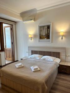 a bedroom with a large bed with two towels on it at Hotel Mireosi in Batumi