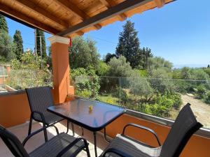 a patio with a table and chairs on a balcony at Eleana's apartments in Gouvia