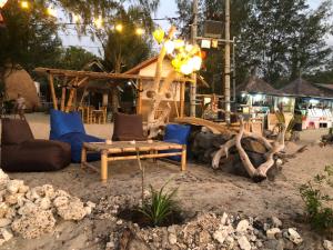 a group of chairs and a table in the sand at La Bohème in Gili Air