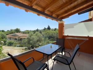 a patio with a table and chairs on a balcony at Eleana's apartments in Gouvia