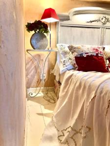ein Schlafzimmer mit einem Bett mit einer roten Lampe in der Unterkunft L’île aux fleurs in Ventabren