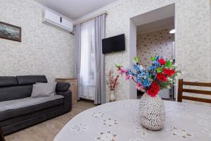 Una sala de estar con una mesa con un jarrón de flores encima. en Apartment Data, en Tiflis