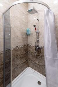 una ducha con puerta de cristal en un baño en Apartment Data, en Tiflis