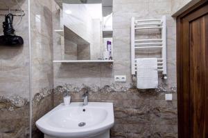 Un baño con lavabo, inodoro y espejo. en Apartment Data, en Tiflis 14 fotos más