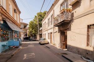 un pequeño coche aparcado al lado de una calle en Apartment Data, en Tiflis