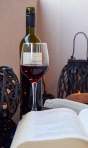 een glas wijn naast een fles wijn bij Apartmani Dina 2 in Posedarje