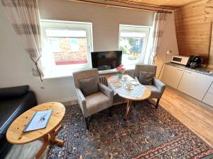 ein Wohnzimmer mit einem Tisch und Stühlen sowie eine Küche in der Unterkunft Haus Inken-Maria Ost in Westerland