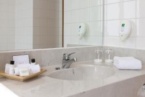 a bathroom counter with a sink and a mirror at Wyndham Garden Donaueschingen in Donaueschingen