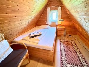 a bedroom with a bed in a wooden cabin at Haus-Inken-Maria-West in Westerland