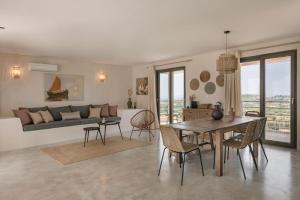 a living room with a table and chairs and a couch at Villa Mirto - Iris sunset villas in Lépedha