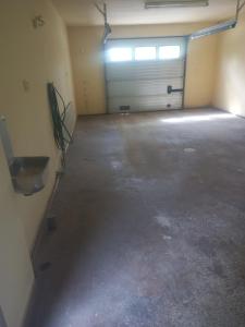 a garage with two garage doors and a concrete floor at 1 bedroom apartment, whole flat in Arvika