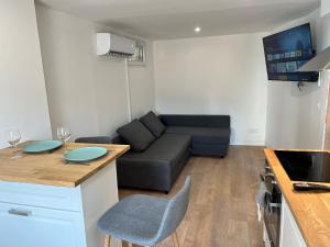 a kitchen and living room with a couch and a table at Studio Neuf CentreVille Climatisé #13 in Toulon