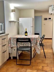 una cucina con tavolo, bicchieri da vino e frigorifero di MINI COCCOLA a Ugento