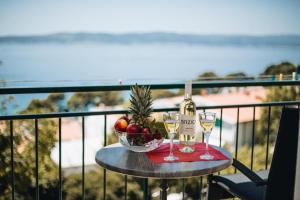 a table with a bowl of fruit and a bottle of wine at Partners Perfect Place in Brela