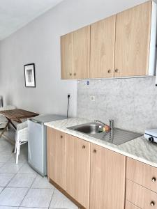 a kitchen with wooden cabinets and a sink and a table at Anthonas House in Nikiti