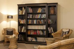 a book shelf filled with books in a living room at Wyndham Garden Donaueschingen in Donaueschingen