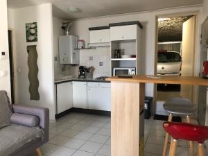 uma cozinha com armários brancos e um balcão de madeira em TheOne Appartement avec garage attenant, entre Montpellier et Sète, près des plages em Villeneuve-lès-Maguelonne