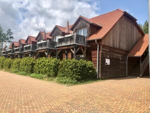 ein großes Holzhaus mit Balkon auf einer Backsteinstraße in der Unterkunft Hotel Der Kräuterhof in Wernigerode