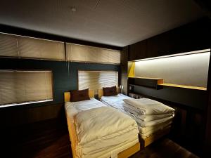 高知市にあるArtist Village Apartments Kochiのベッドルーム1室(ベッド2台、窓2つ付)