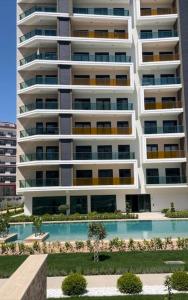 een groot appartementencomplex met een zwembad ervoor bij Квартира в центрі Avssalar in Avsallar