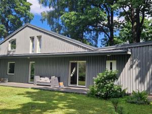a gray house with a couch on a porch at Zalves House in Riga