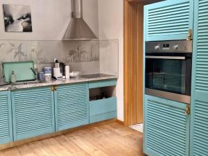 a kitchen with blue cabinets and a sink at Zalves House in Riga