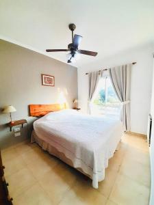 a bedroom with a bed and a ceiling fan at Aromas del Alba in San Clemente del Tuyú