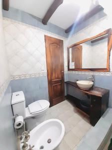 a bathroom with a white toilet and a sink at Aromas del Alba in San Clemente del Tuyú
