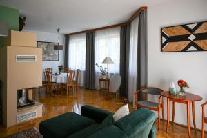 a living room with a green couch and a table at Kozmáry Vendégház in Matrafured