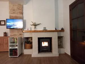 un soggiorno con camino in mattoni e TV di La Casa del Abuelo Curro a Baños de la Encina