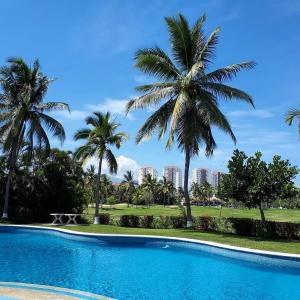 a swimming pool with palm trees in the background at marina vallarta, One bedroom condo in Puerto Vallarta