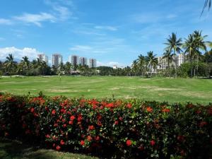 a park with flowers and palm trees and buildings at marina vallarta, One bedroom condo in Puerto Vallarta